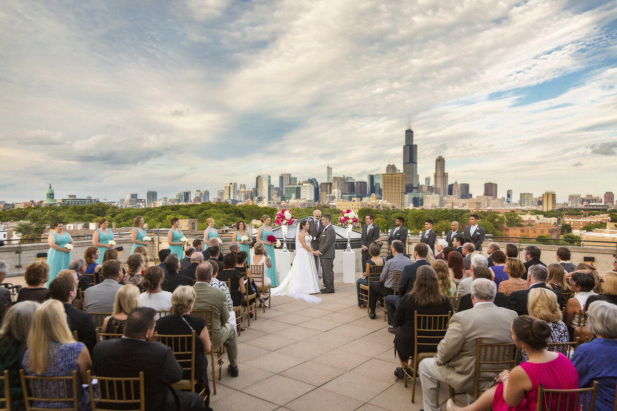 A wedding ceremony on a rooftop overlooking the Chicago skyline.