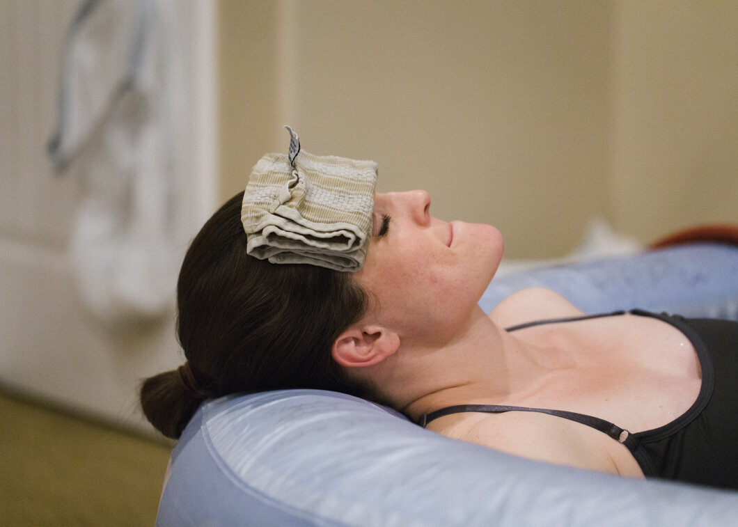 A pregnant mother relaxes in a birthing tub.