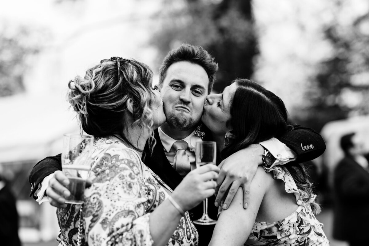 Guests kissing one of the groomsmen