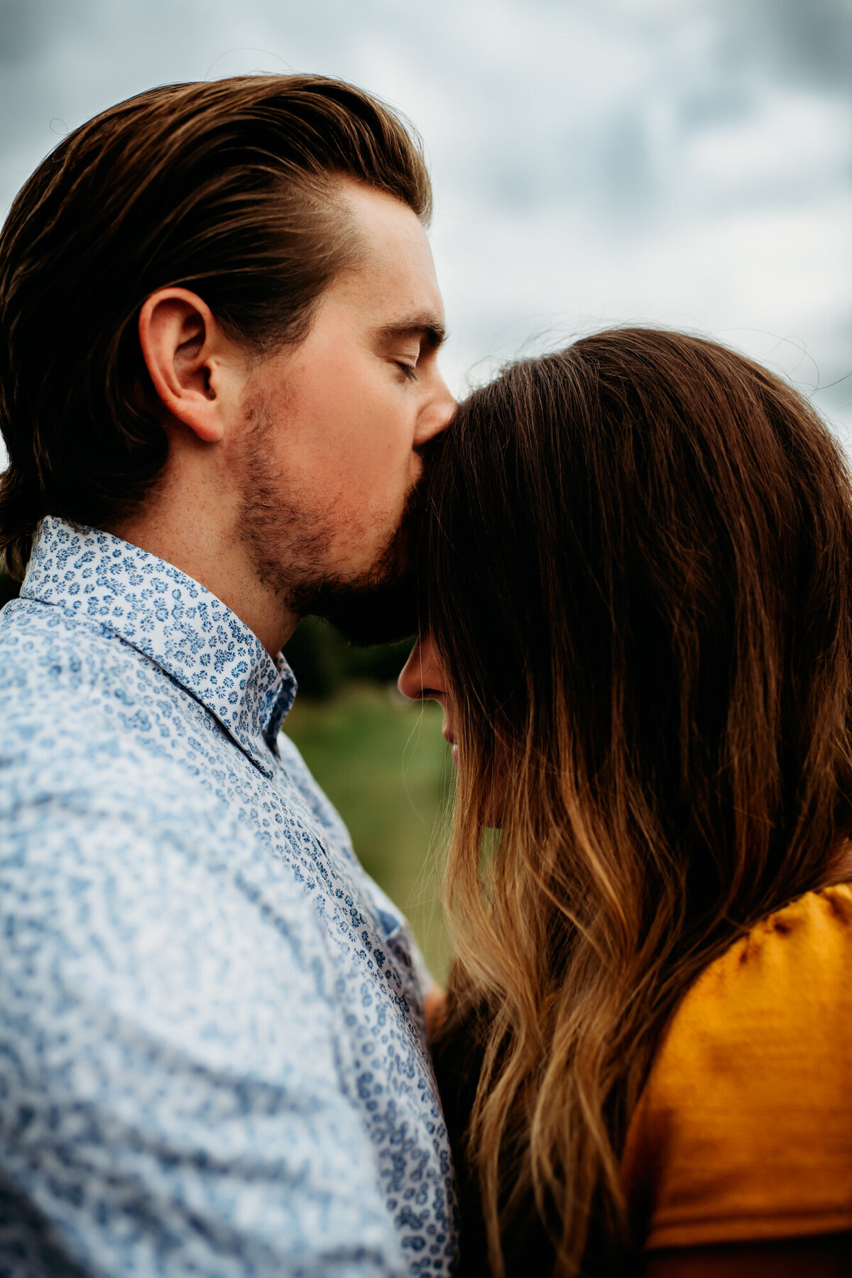 Couples Photography, man kisses woman on the forehead affectionately