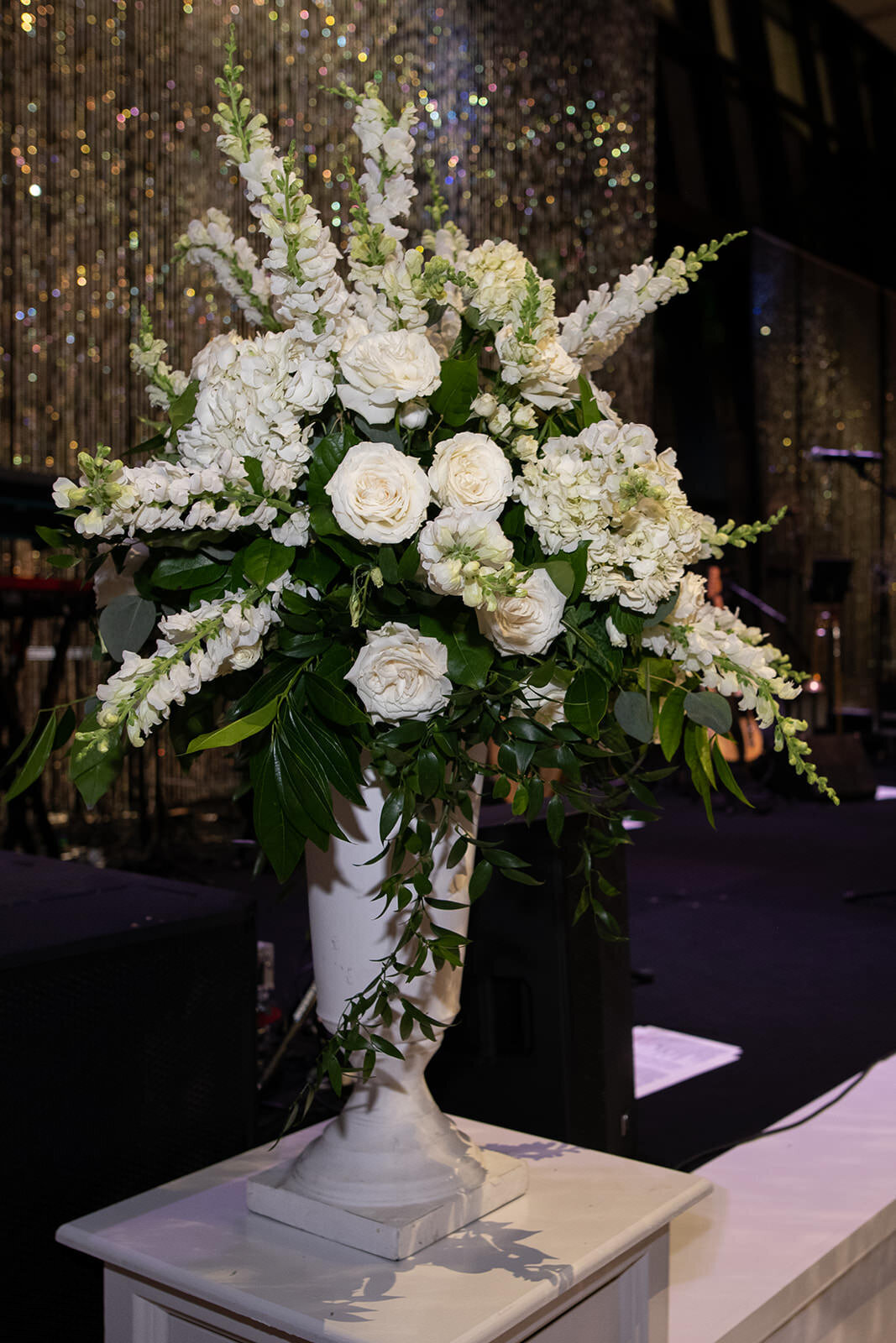 White Floral wedding urn for band stage at Hillwood Country Club