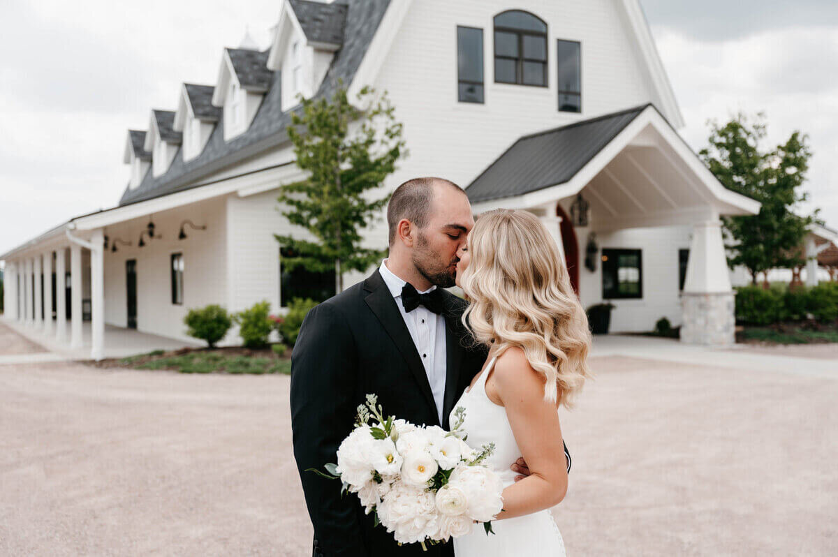 Bride and groom kissing in front of wedding venue planned by best wedding planners in chicago