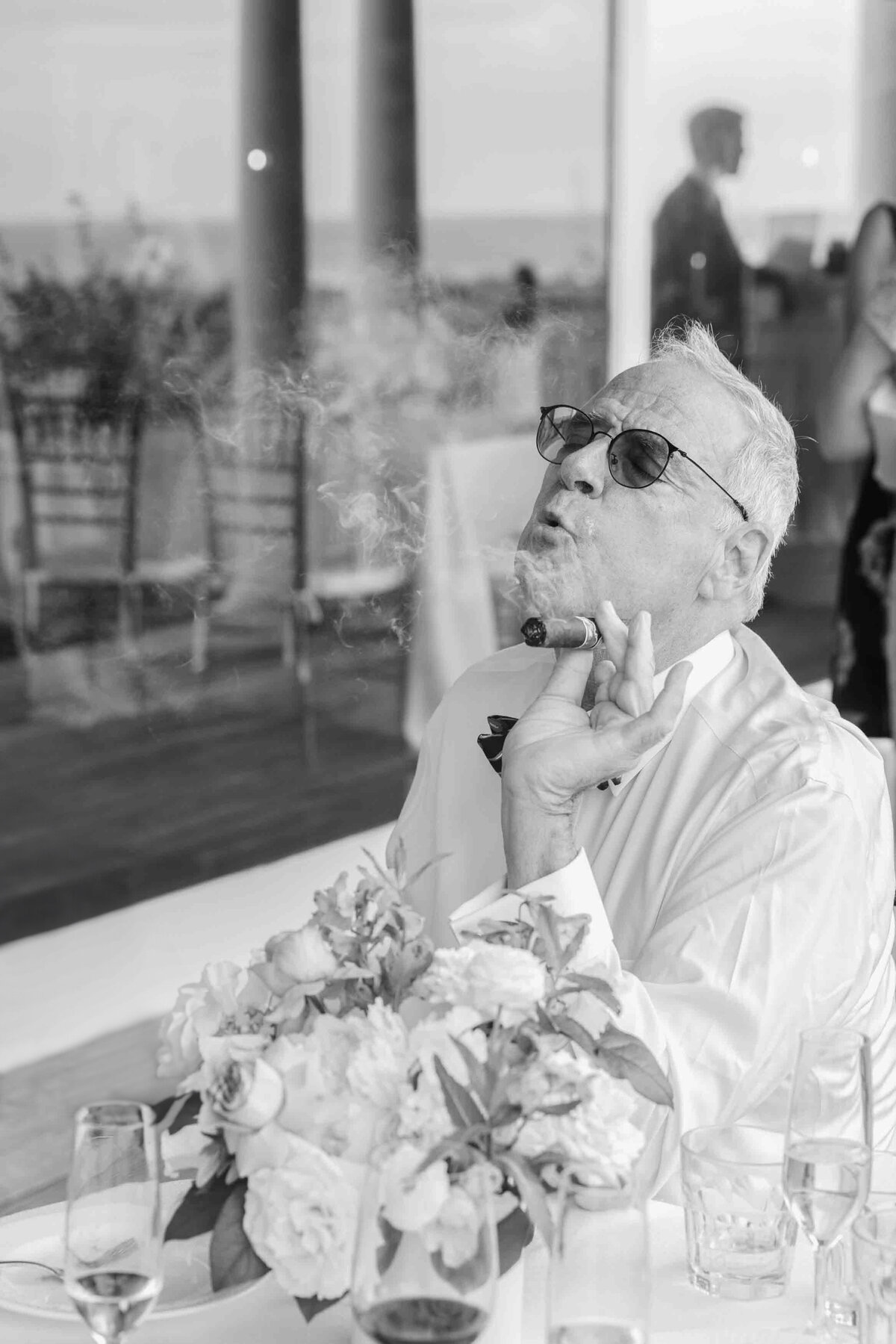 grandfather of the groom smoking a cigar and blowing smoke