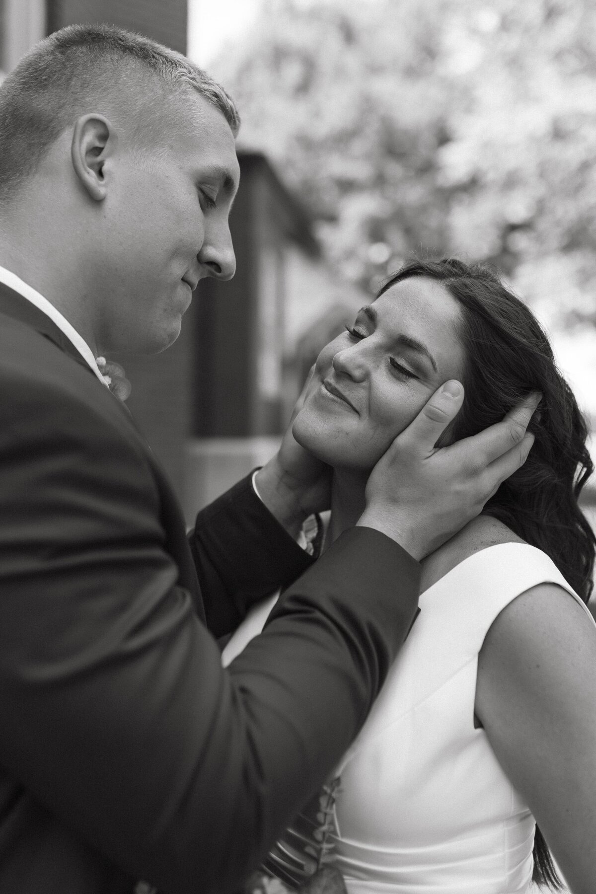 groom caressing brides face