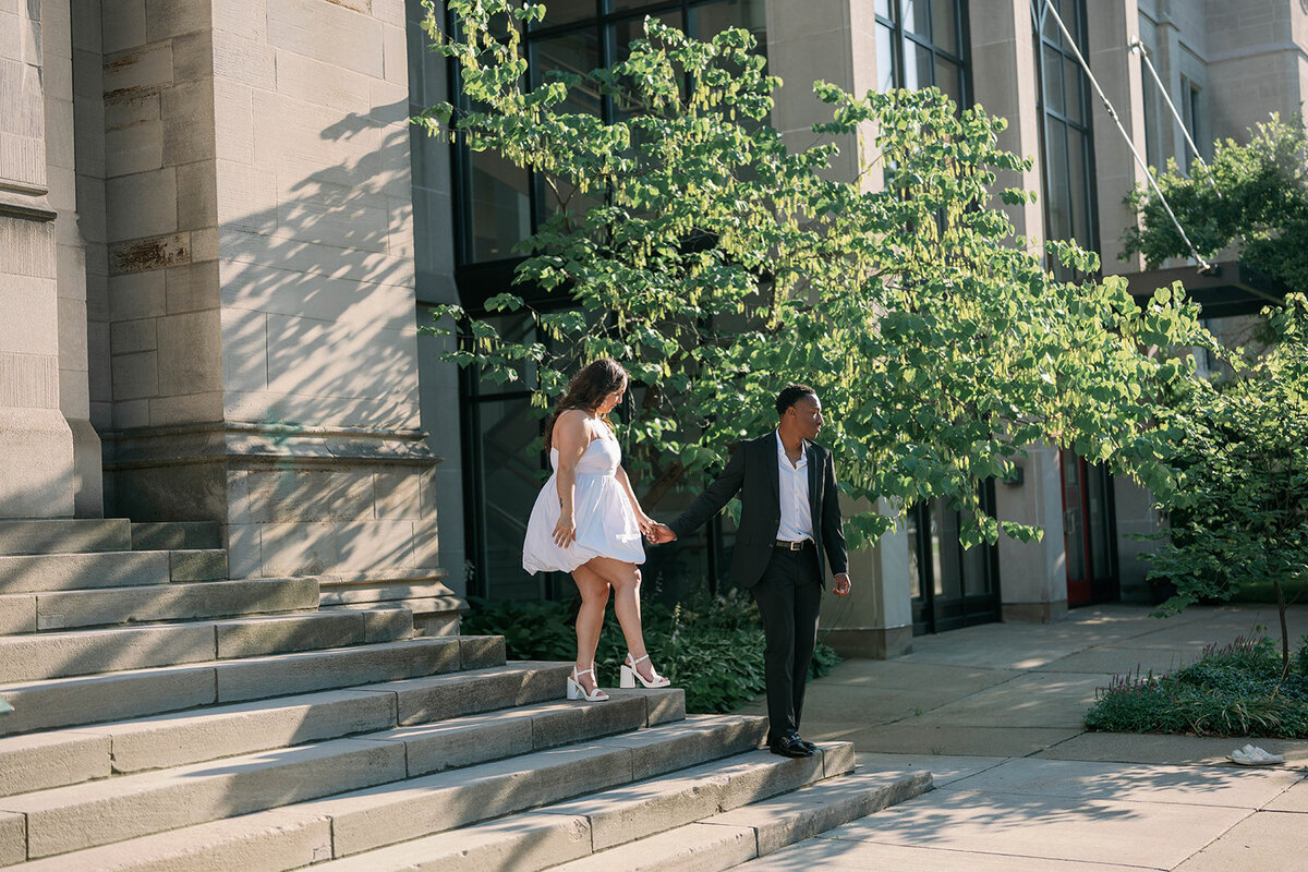 Modern Kalamazoo engagement pictures of couple walking down stairs together.