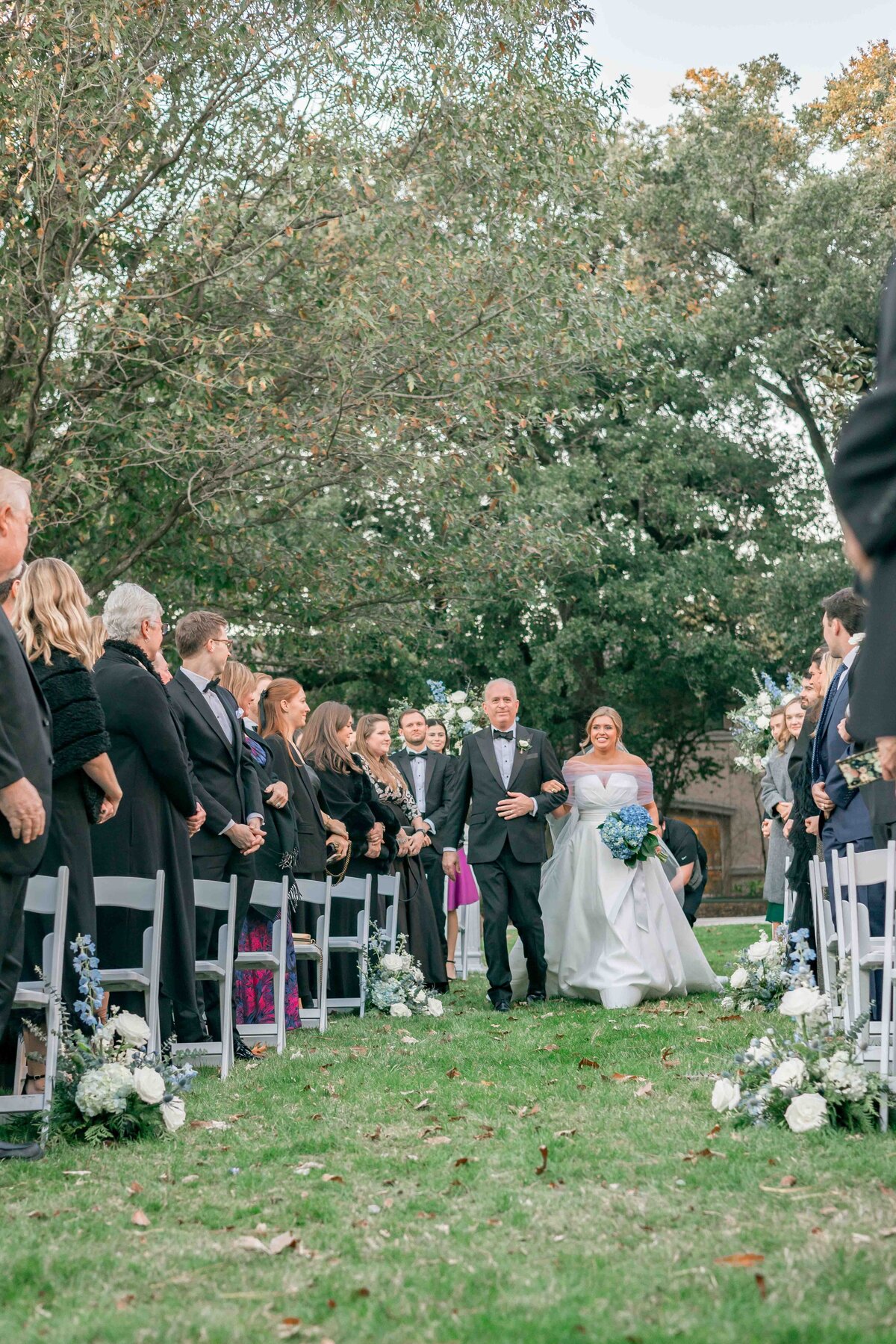 bride is being walked down the aisle by her father at the houstonian hotel and spa