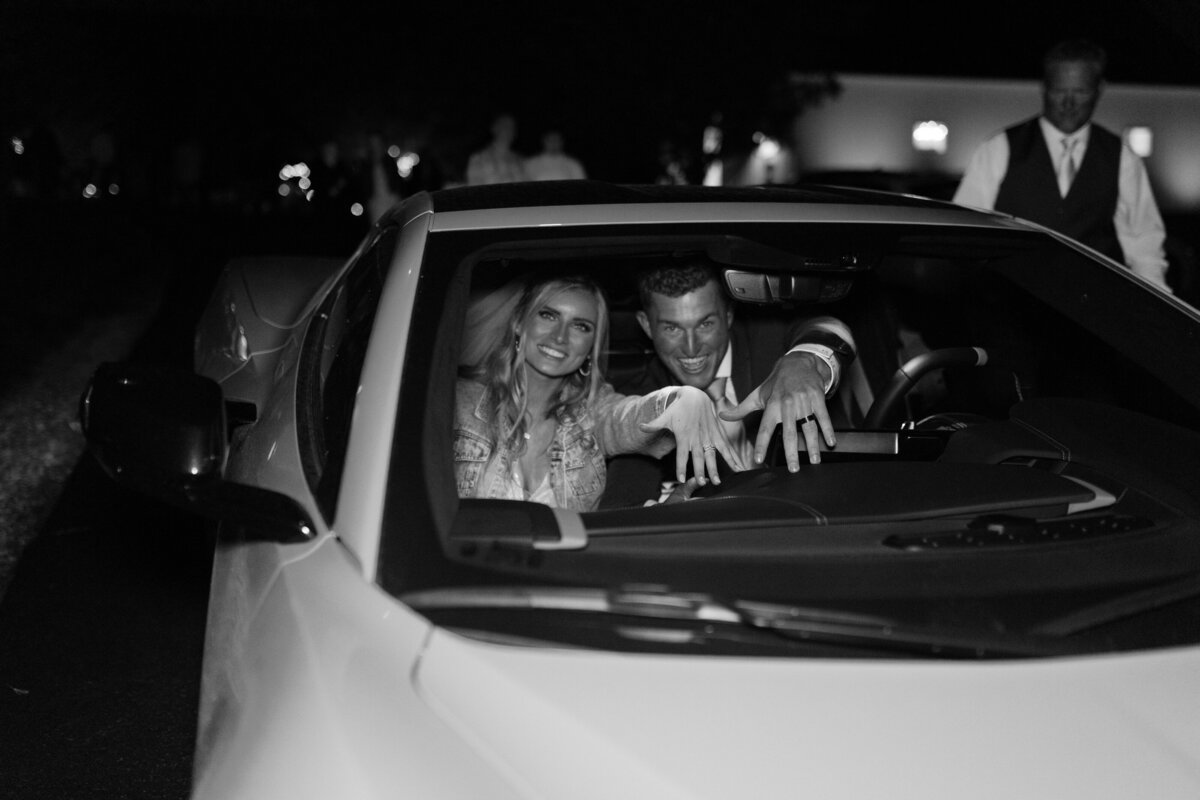 The couple showing their rings from inside the car as they drive off.