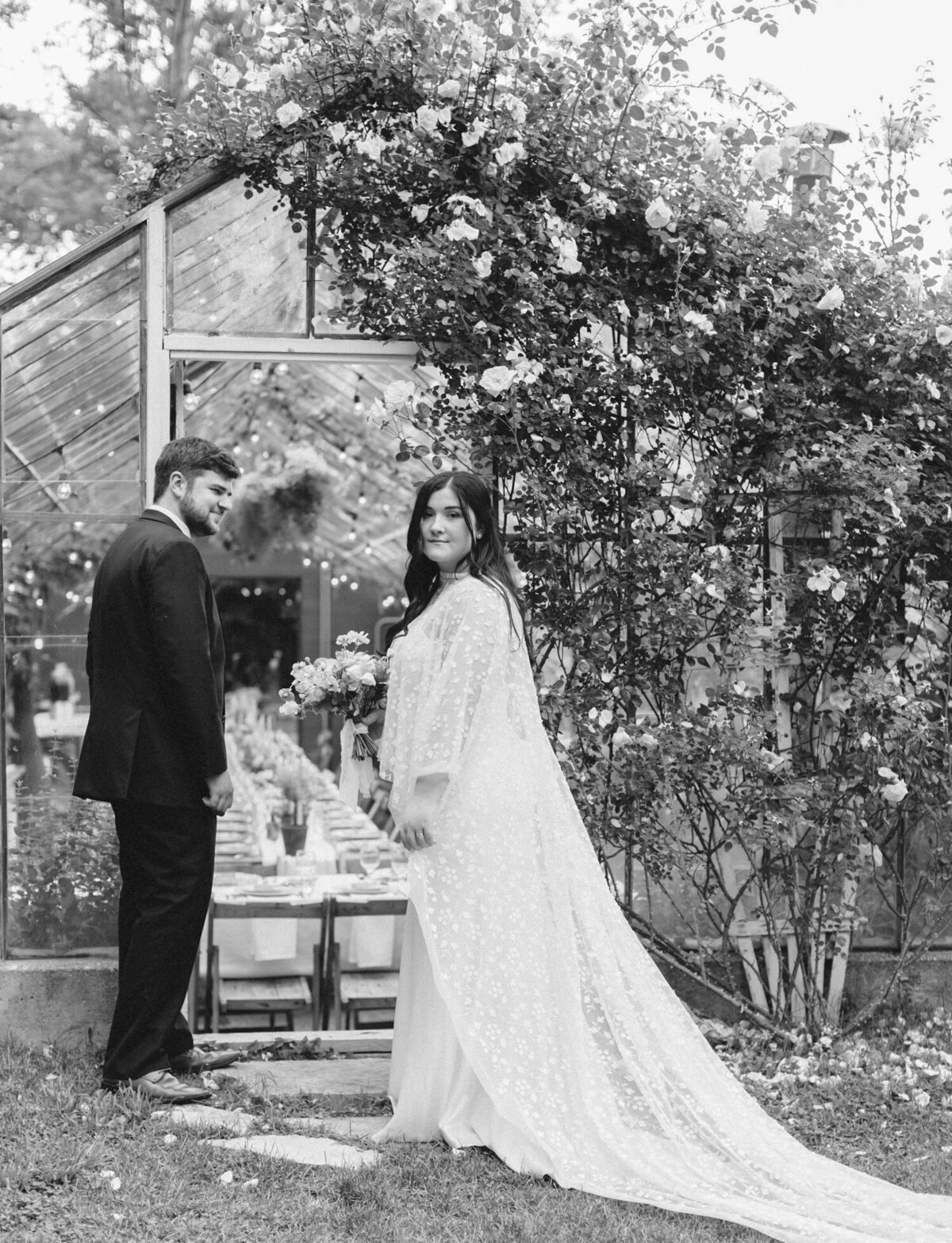 bride and groom at glass greenhouse wedding venue with flowers, Michigan