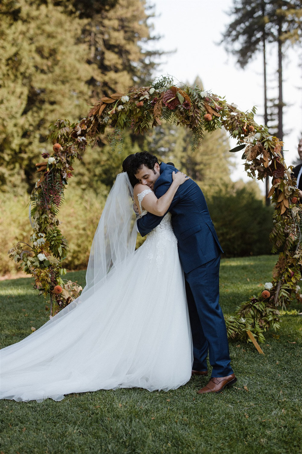 Bride and groom hugging in front of their wedding altar