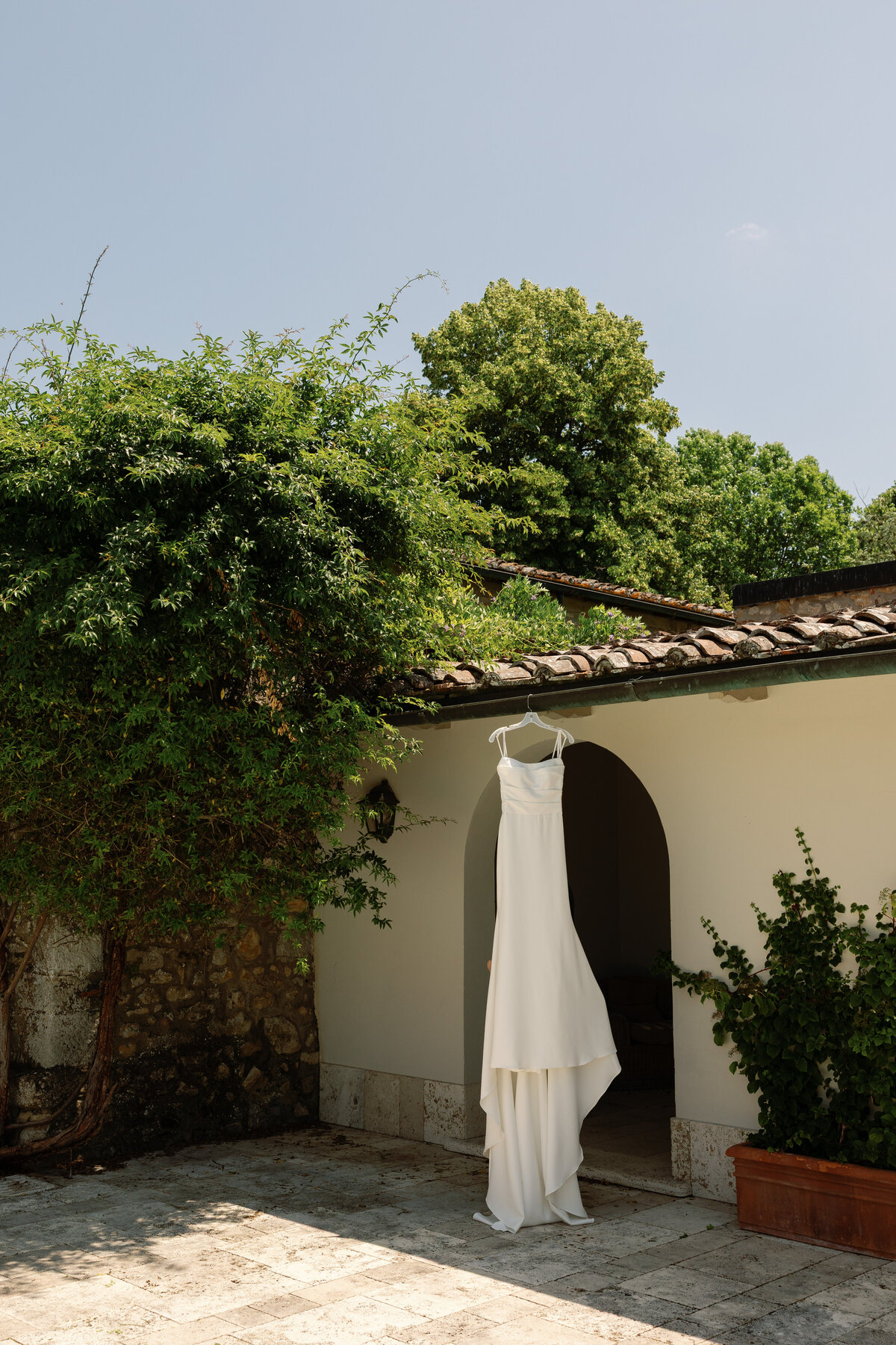  Elegant bridal dress hanging in Villa La Selva before the ceremony