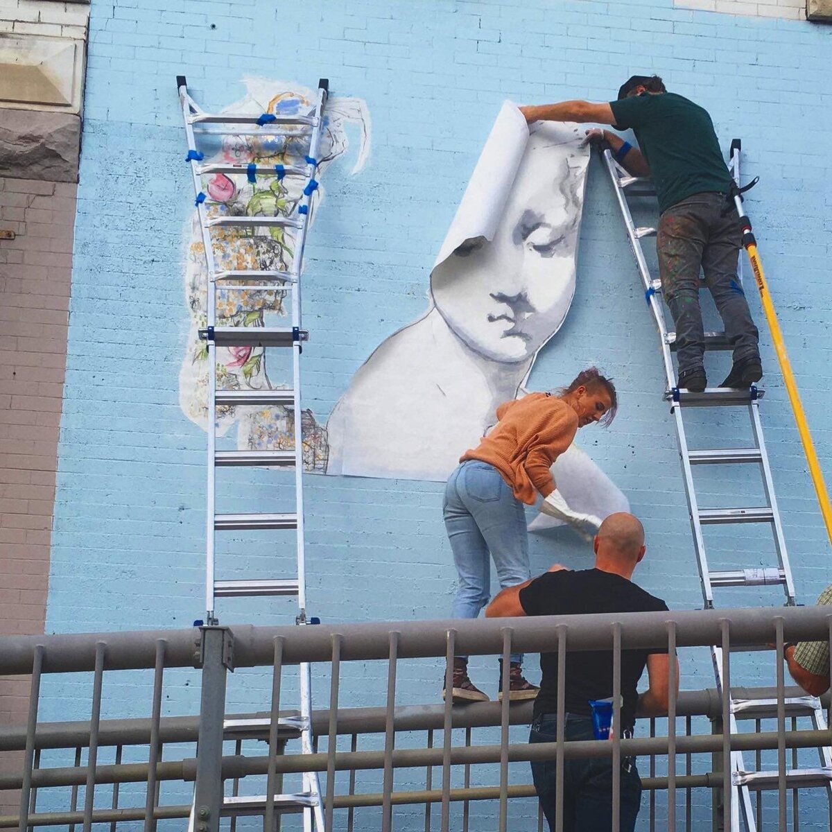 Artist Cam Rose and team installing mural