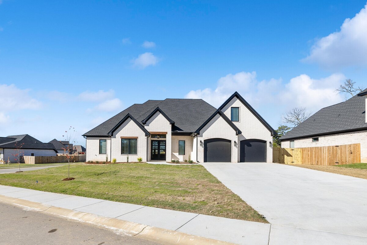 Front of 6011 Majestic Waters. White house with black trim and wood details.
