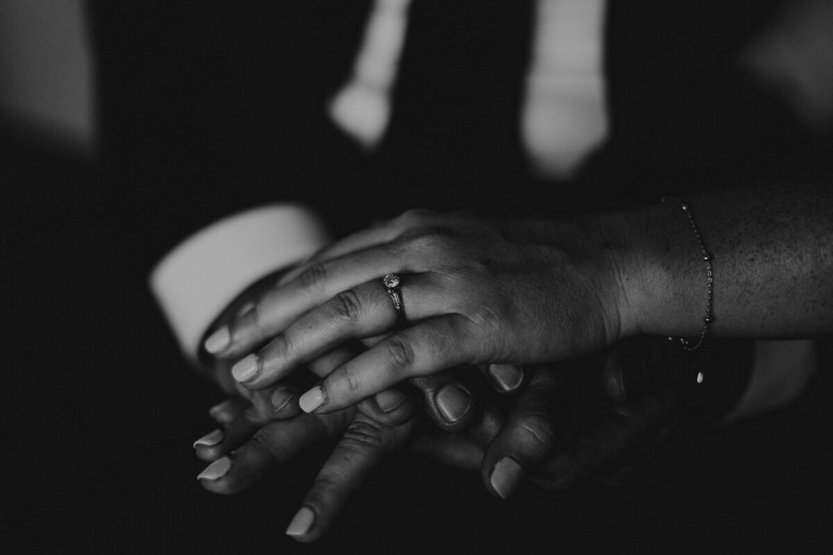 close up of bride and grooms hands with rings
