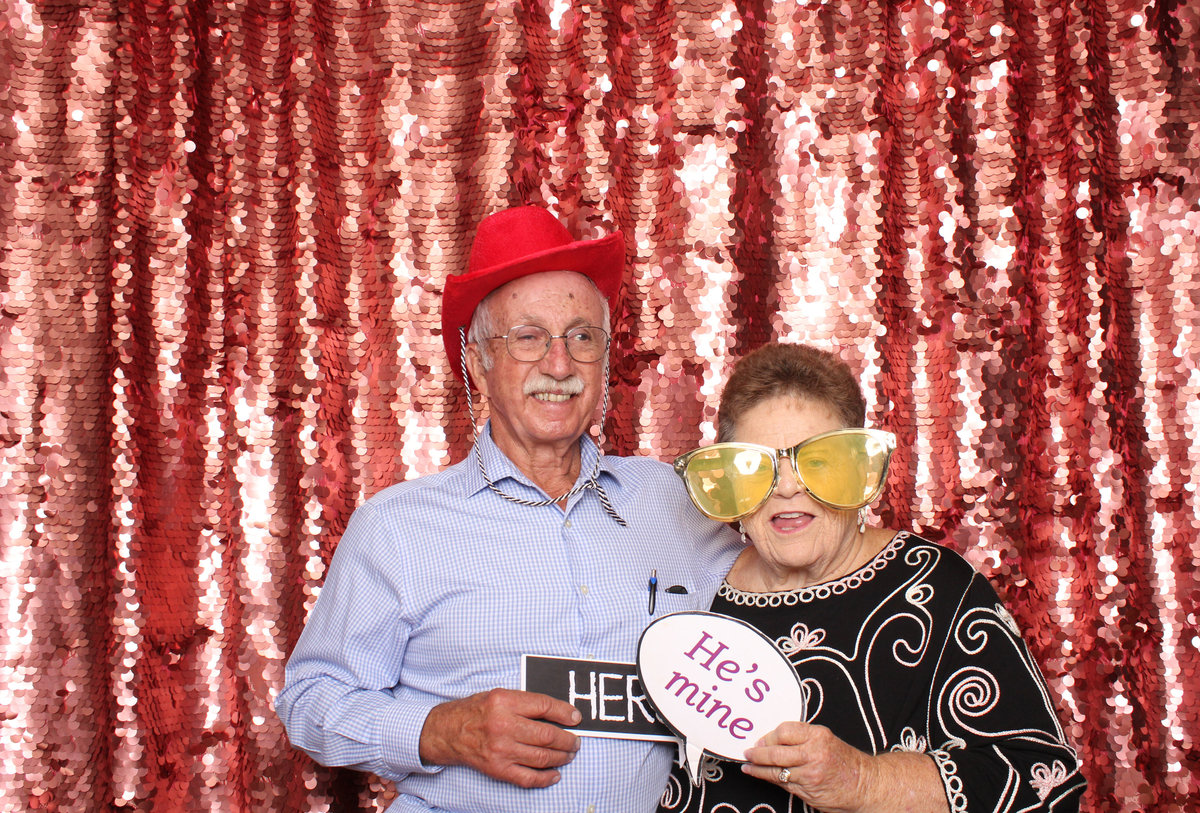 Man and Woman dress up and  pose in a photo booth rental