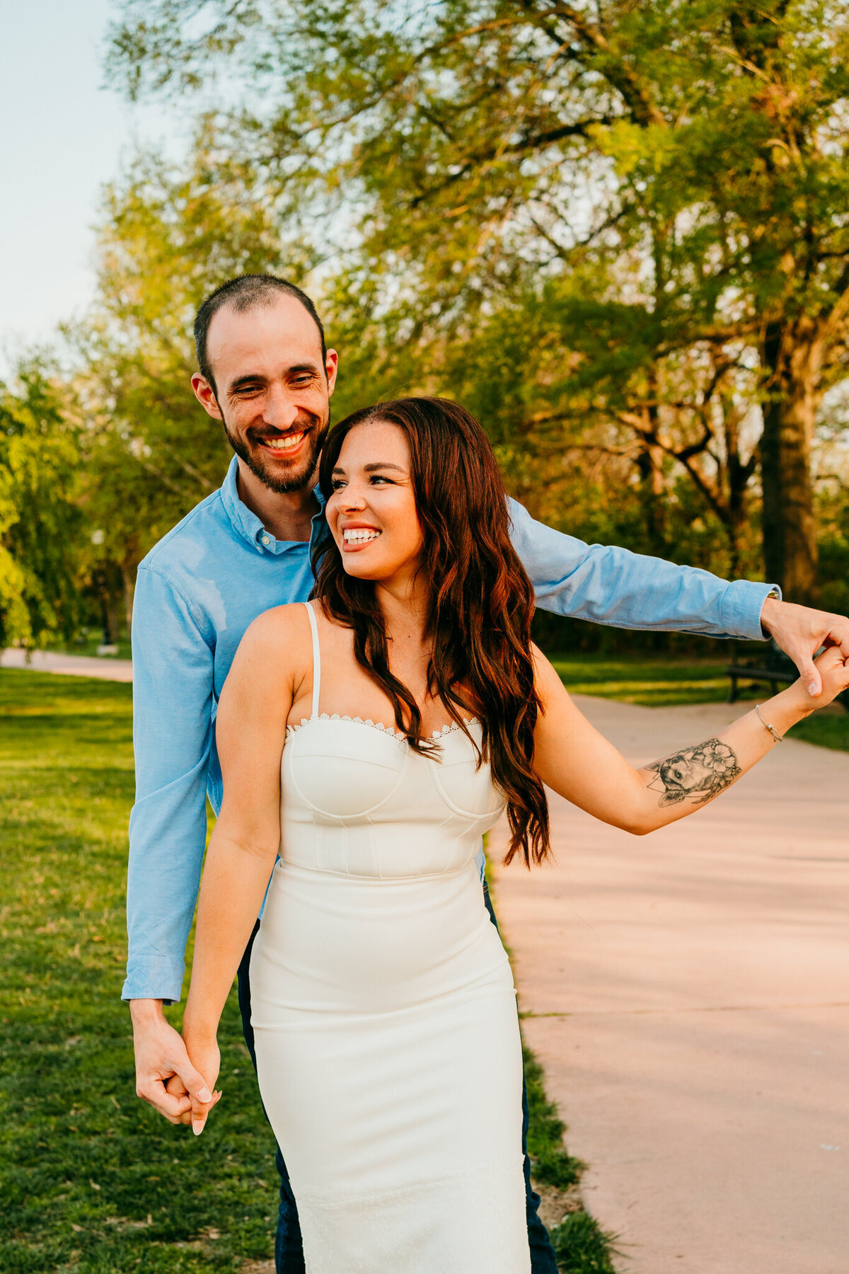 Romantic engagement session with couple laughing in a park