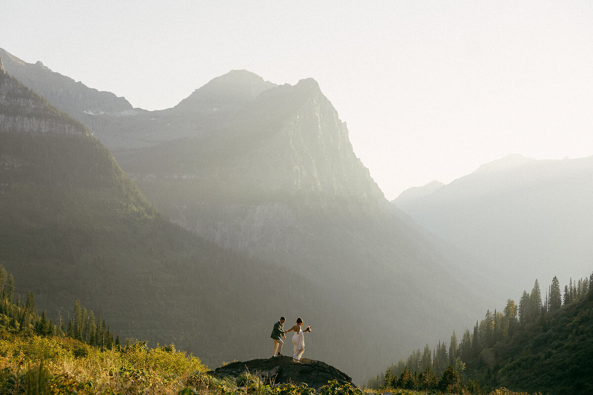 Couple climbing big rock at Big Bend in Glacier National Park