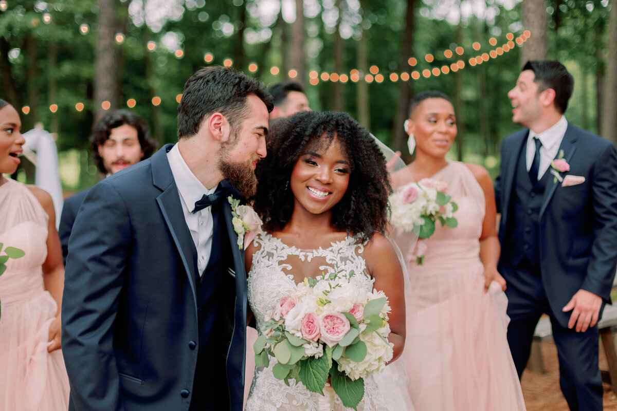 A newlywed smiling and looking at their partner standing next to them 
