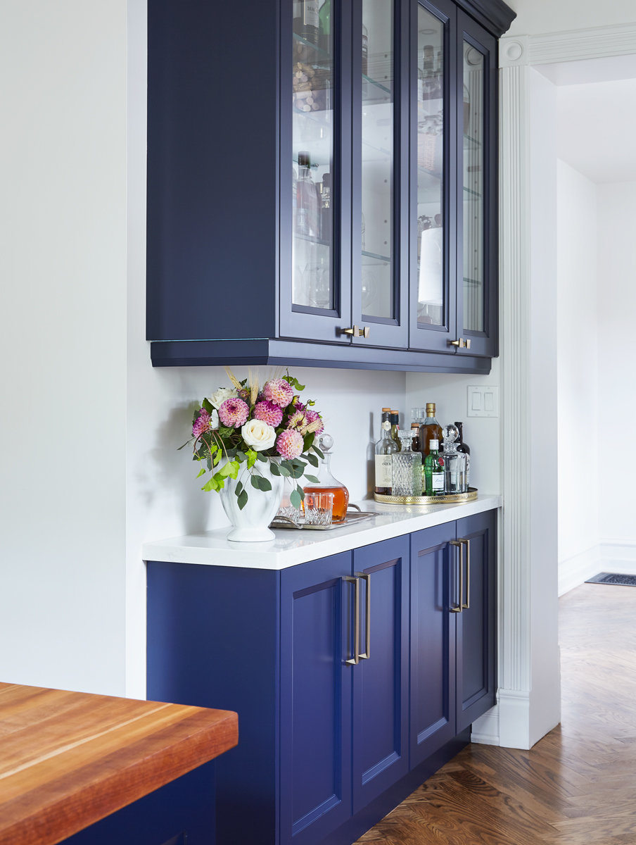 blue kitchen cabinets and flowers on bar area in Burlington interior designer's home