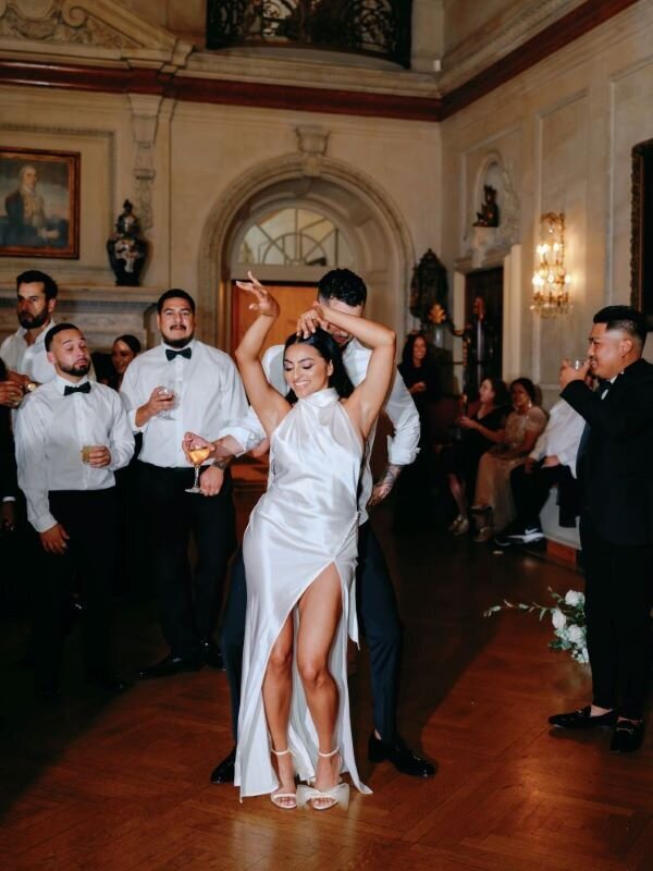 Bride and groom dance surrounded by their guests in the grand ballroom at their Larz Anderson House Wedding.