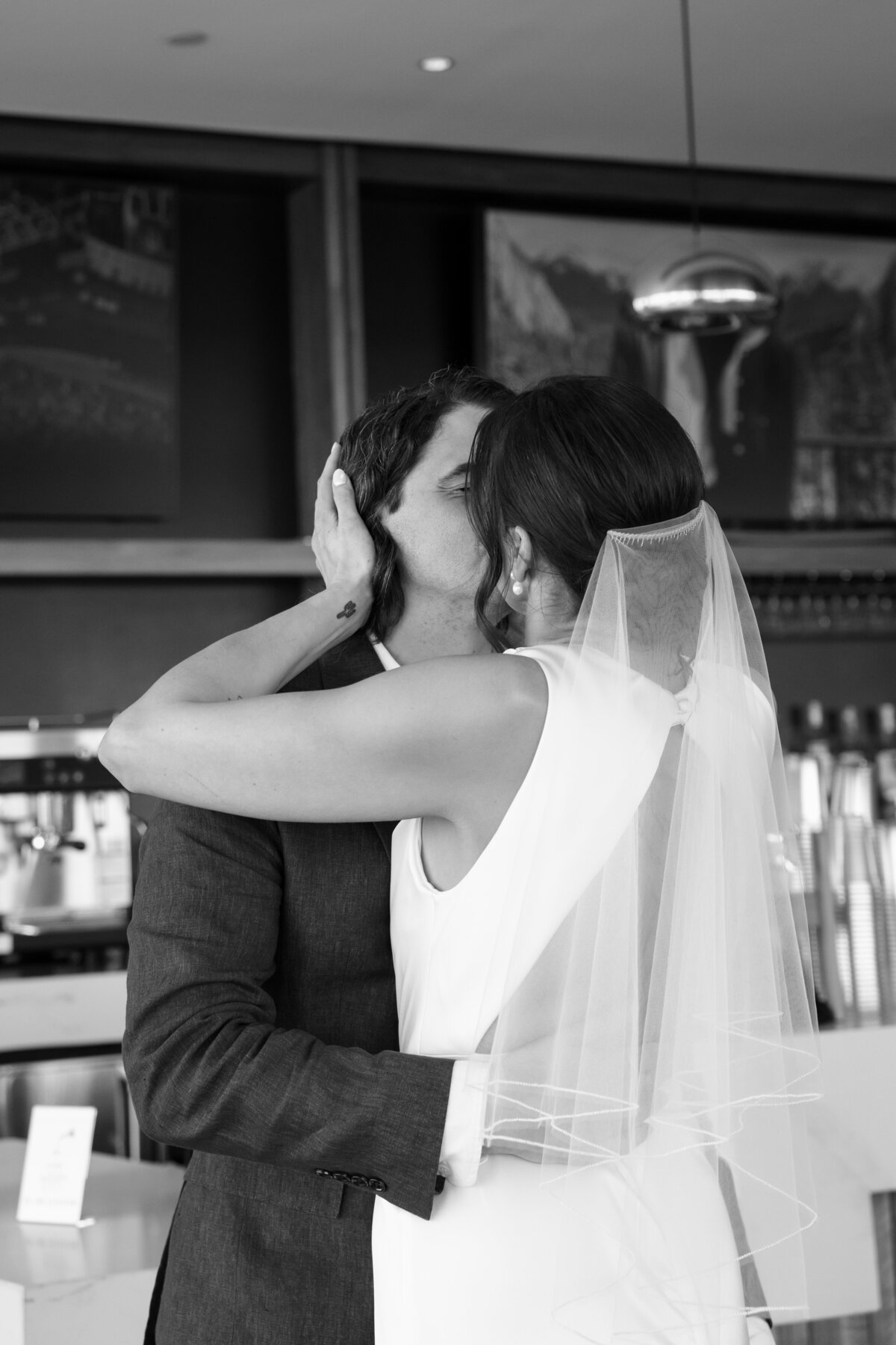 bride kissing groom for their wedding photos in austin
