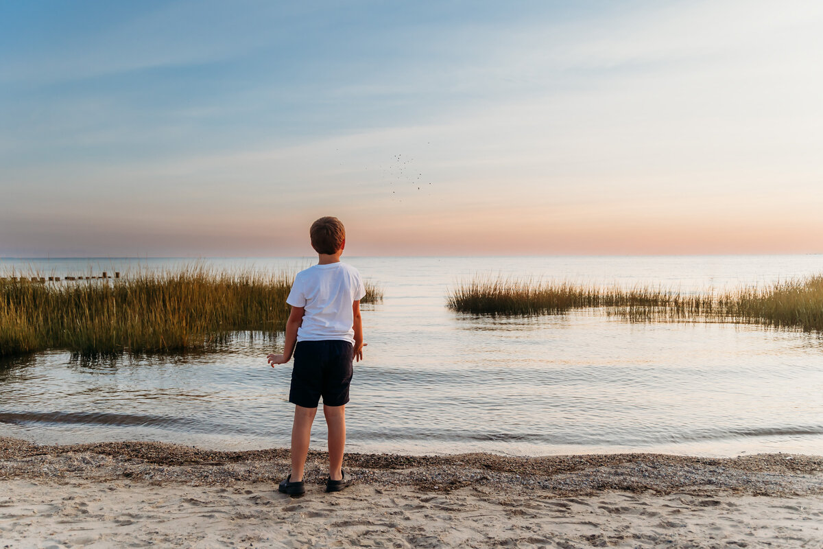 cute_boy_throwing_rocks_beach.jpg