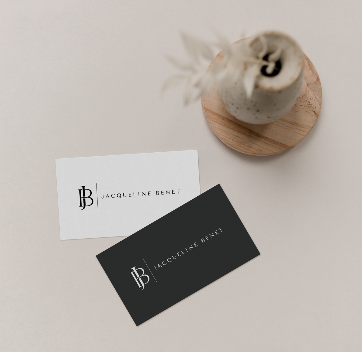 Two business cards, one in white with black lettering and one in black with white lettering displayed againsta marble countertop.