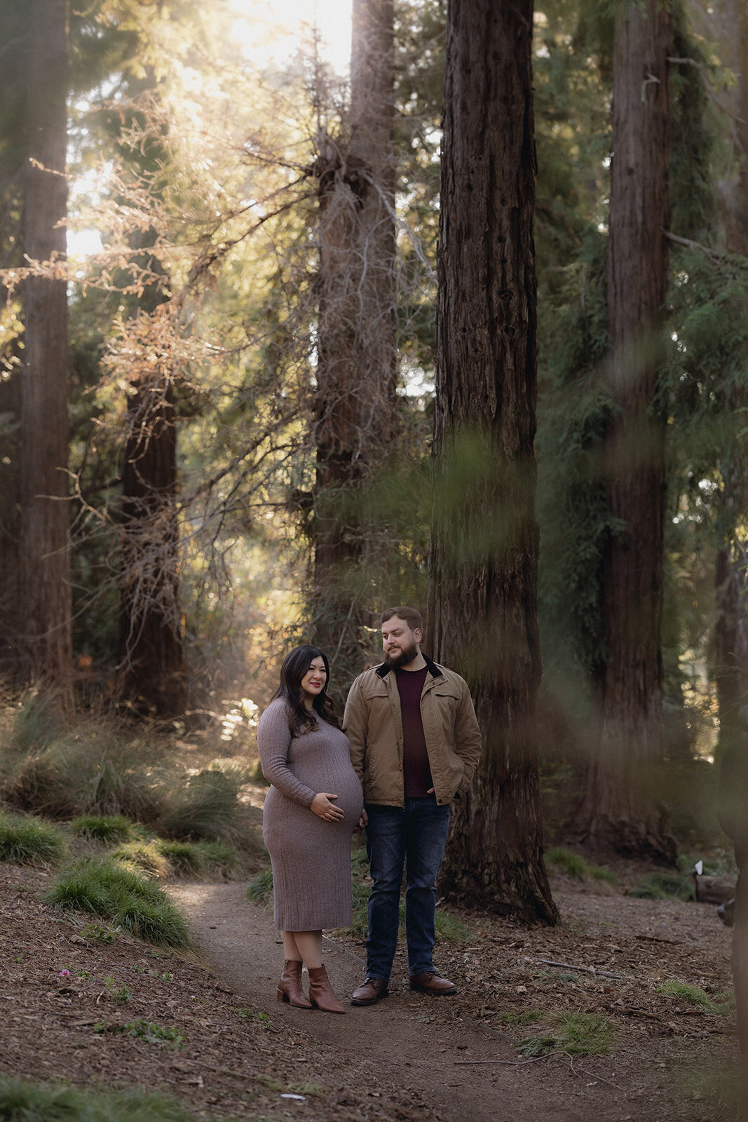 A couple sharing a quiet moment in a redwood forest, blending documentary wedding photography with an editorial feel.