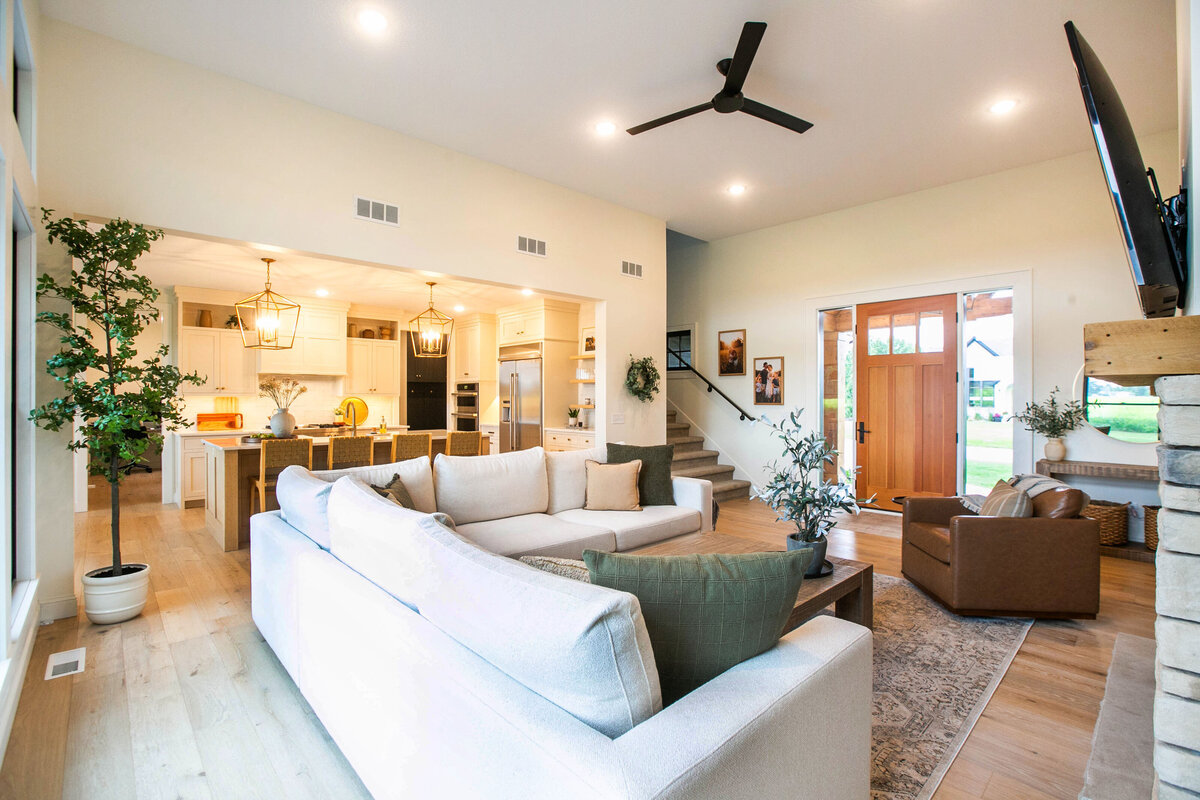 Cozy living room in Otsego custom home with fireplace, built-ins, and large windows