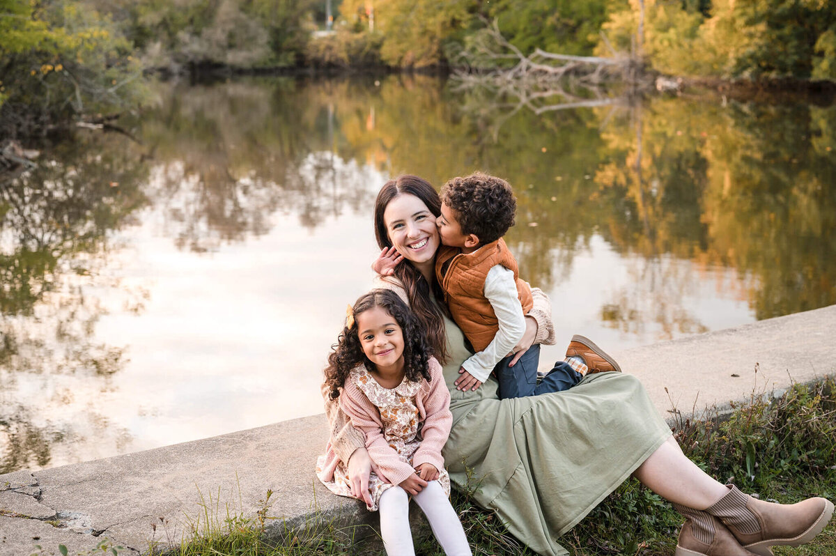 Mom hugging her kids next to a lake