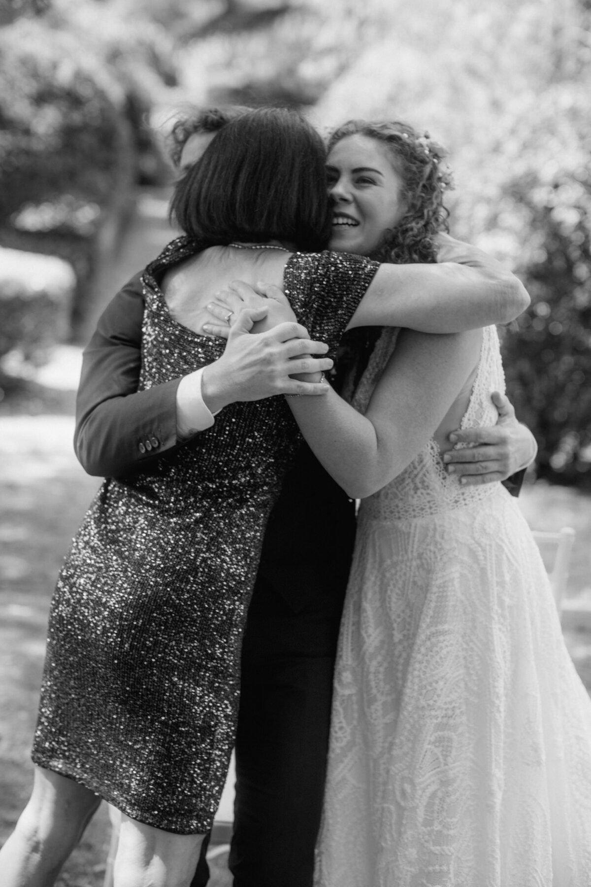 A special moment as the wedding couple hugs the grooms mom.