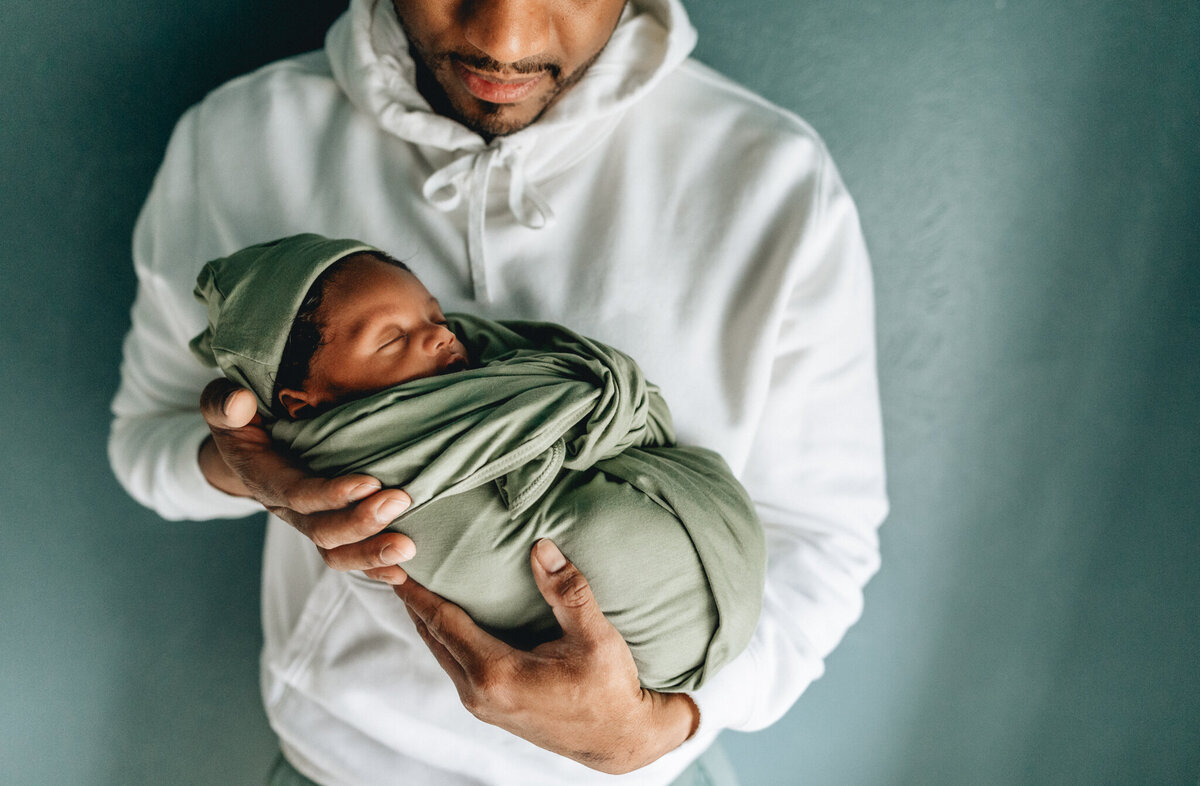 Family photography of dad holding newborn baby