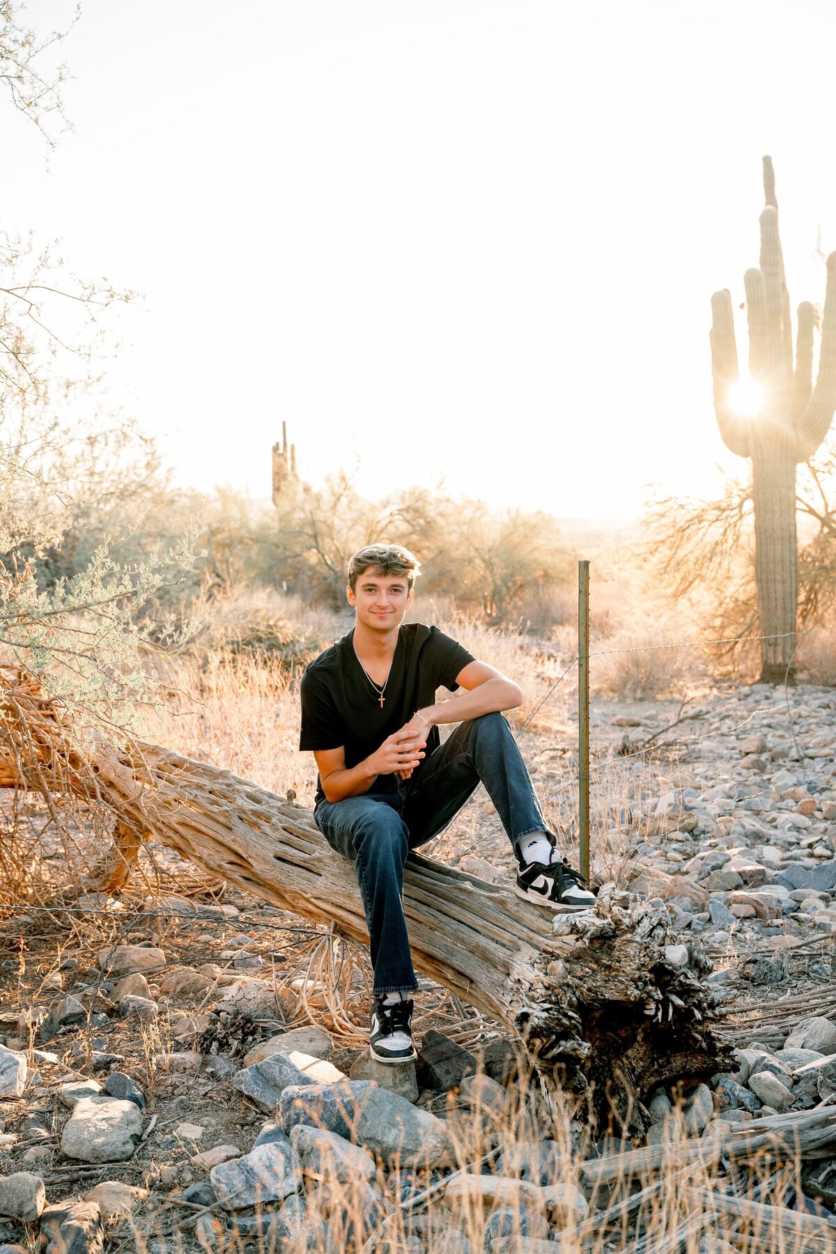 senior boy in arizona desert smiling at the camera 