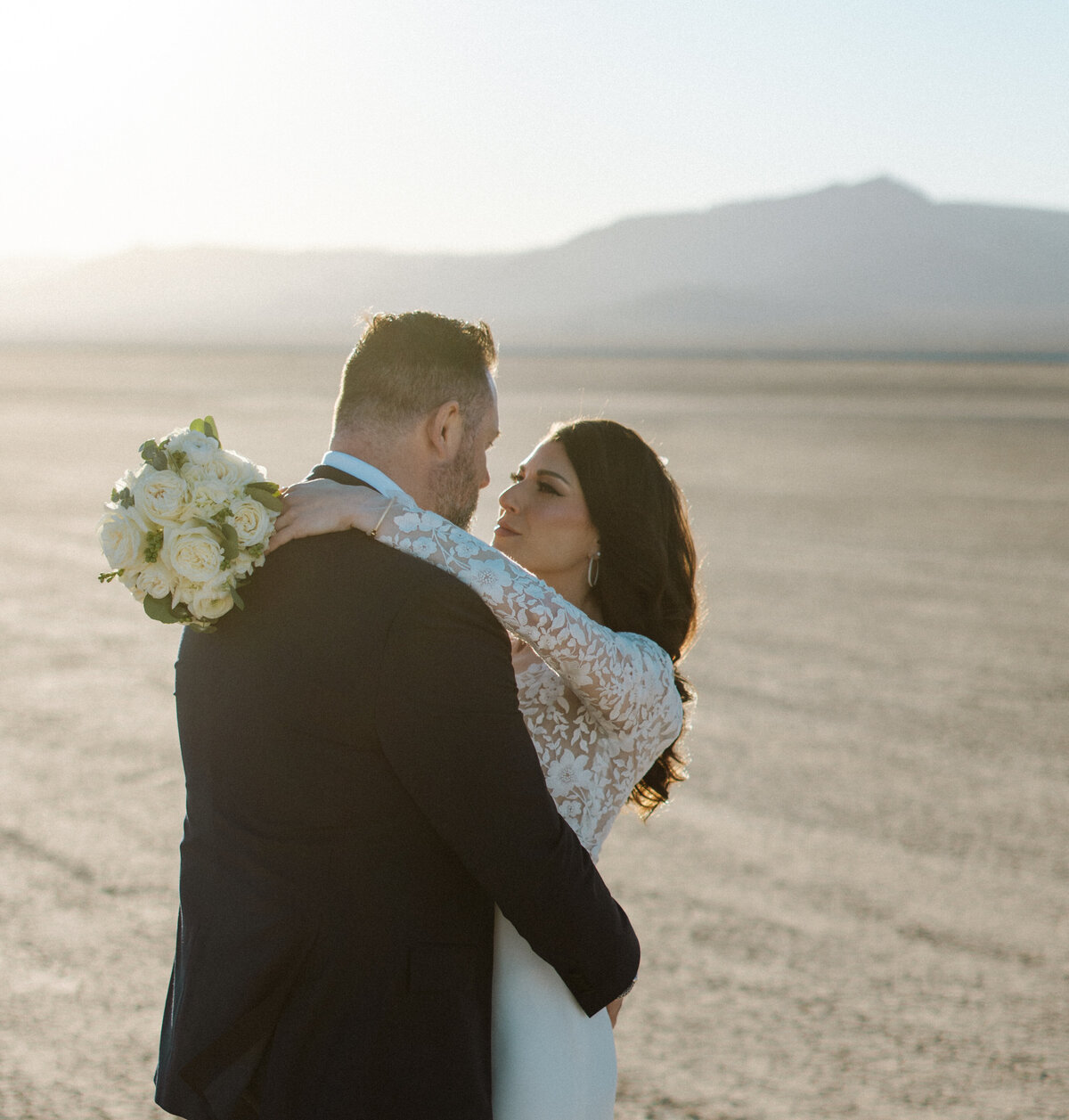 bride and groom stare into each others eyes at the dry lake bed just outside of las vegas