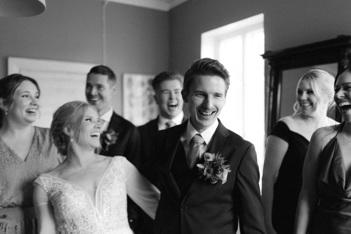 A documentary wedding  photo of the bride and groom with their entourage in Oitbacka gård captured by wedding photographer Hannika Gabrielsson in Finland