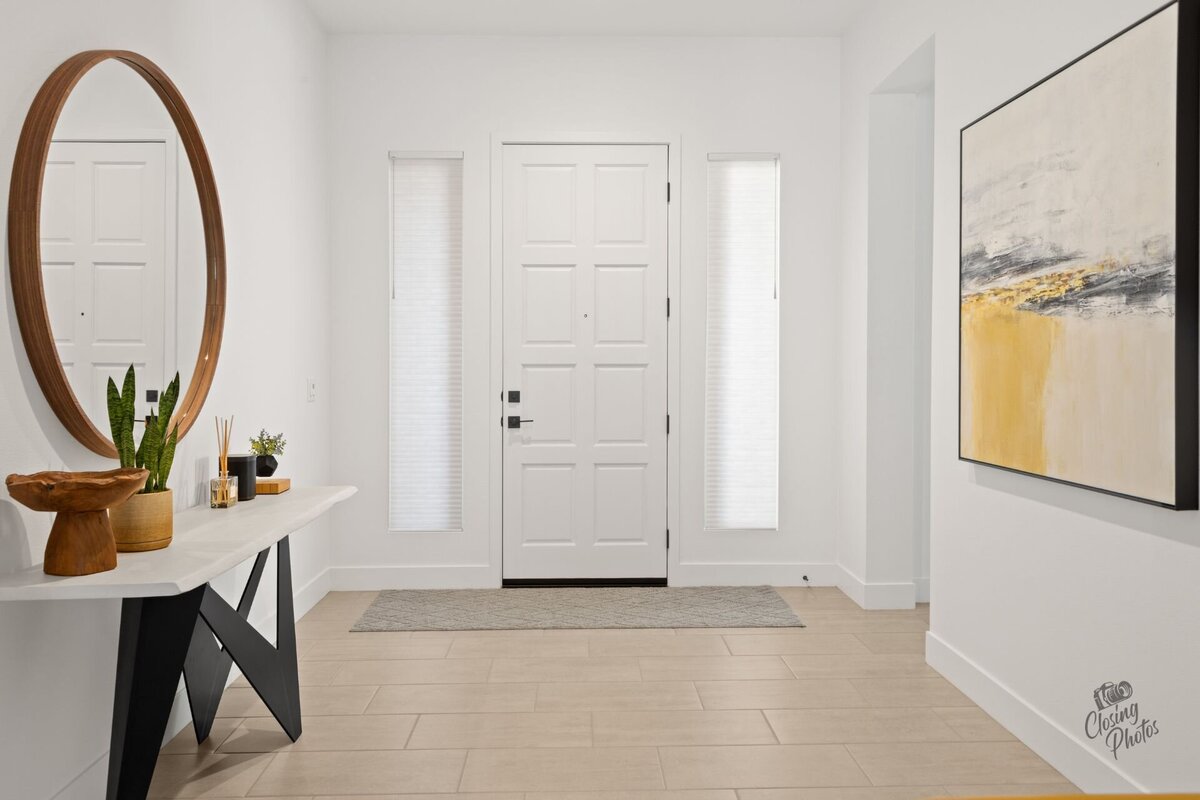 Modern and minimal entryway with bright white walls and view of the front door.