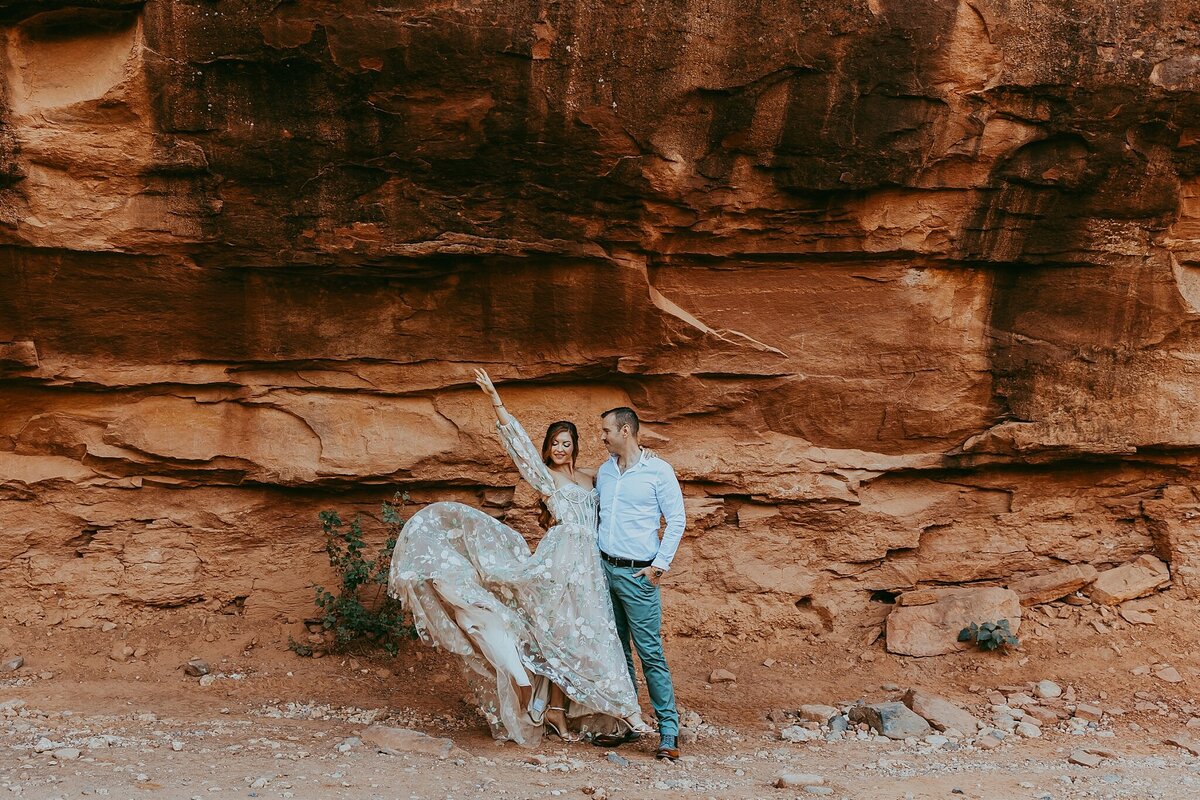 couple stands in front of red rocks in sedona arizona
