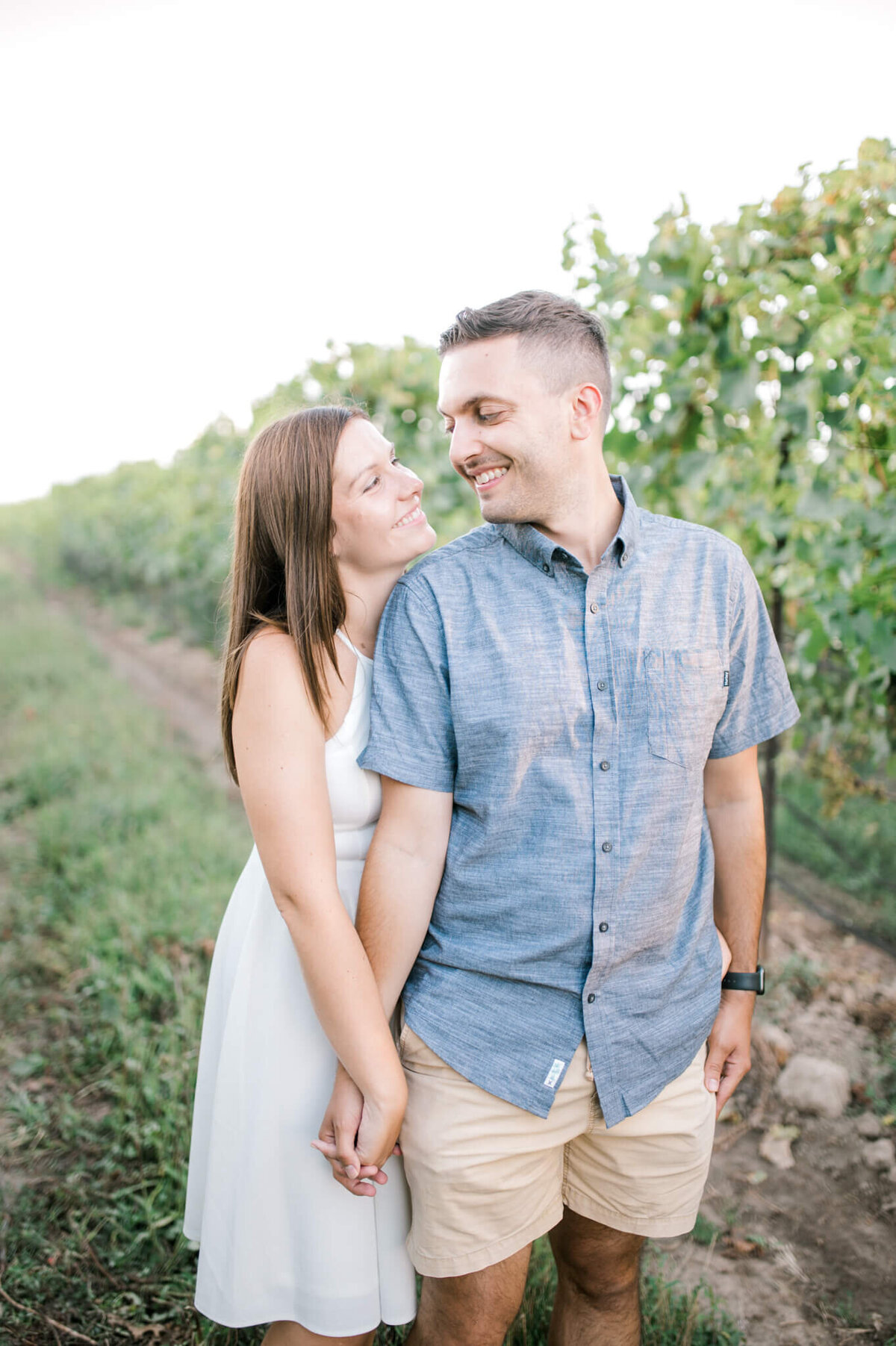 Engaged couple pose for Niagara Wedding Photographer Kristine Marie at a winery.