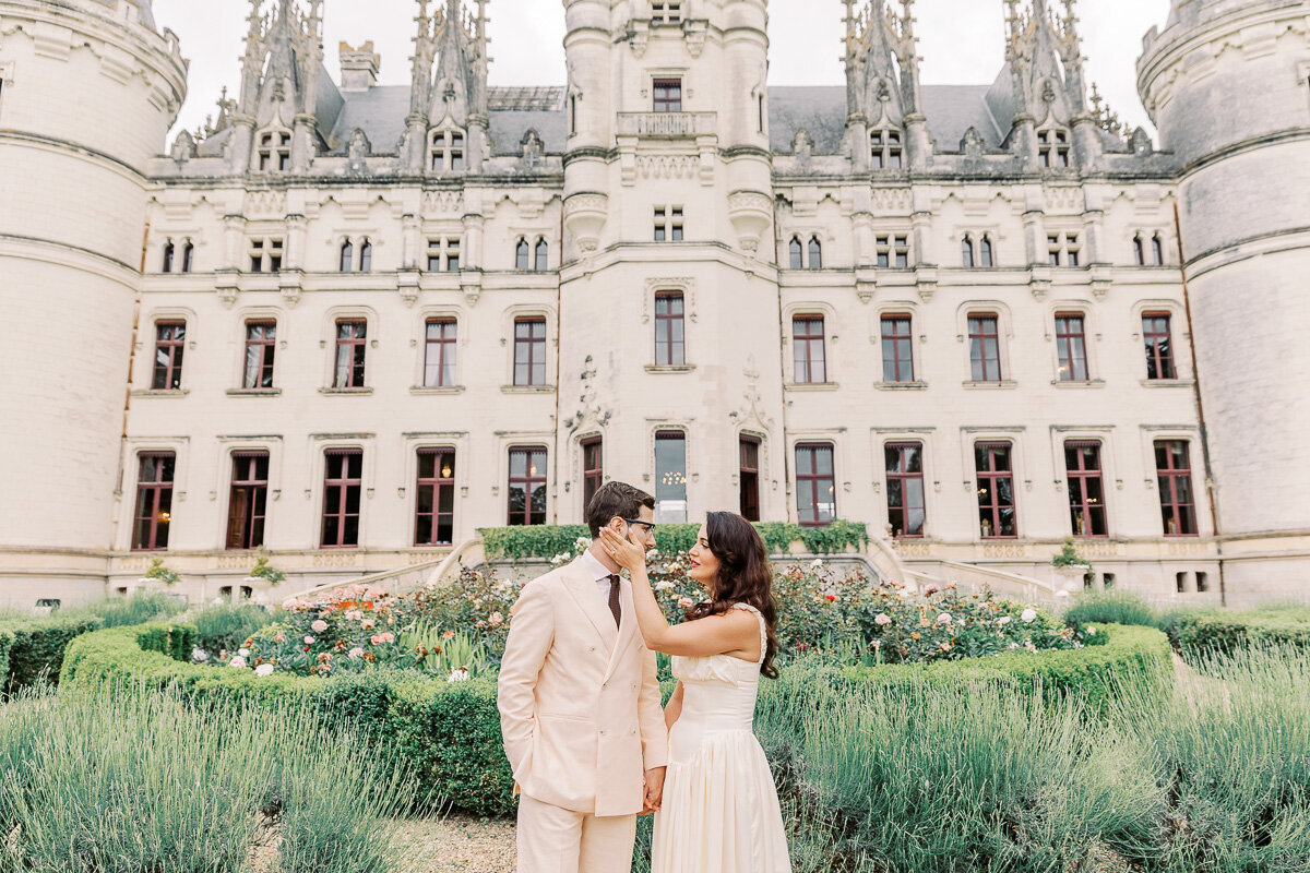 Bride and groom sharing a romantic moment during their pre-wedding celebration at Château Challain, captured outdoors in elegant, natural wedding photography
