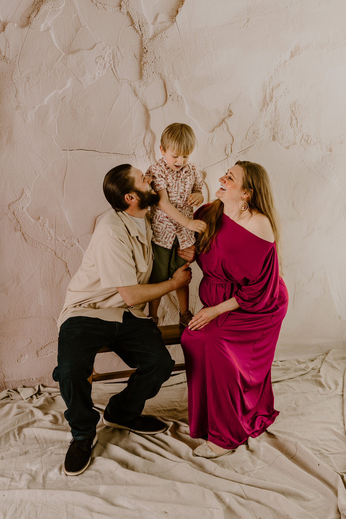 studio-family-photo-posing-against-textured-wall-des-moines-iowa-storyteller-collective-photo-co