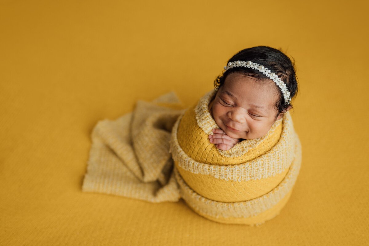 baby girl smiles during newborn session in tampa