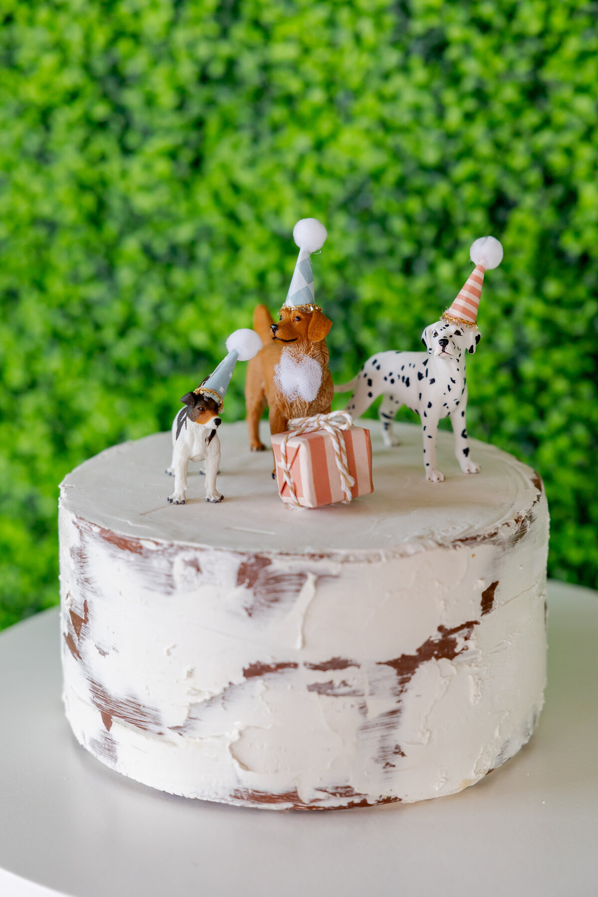 Faux cake with dog figurines wearing party hats. 