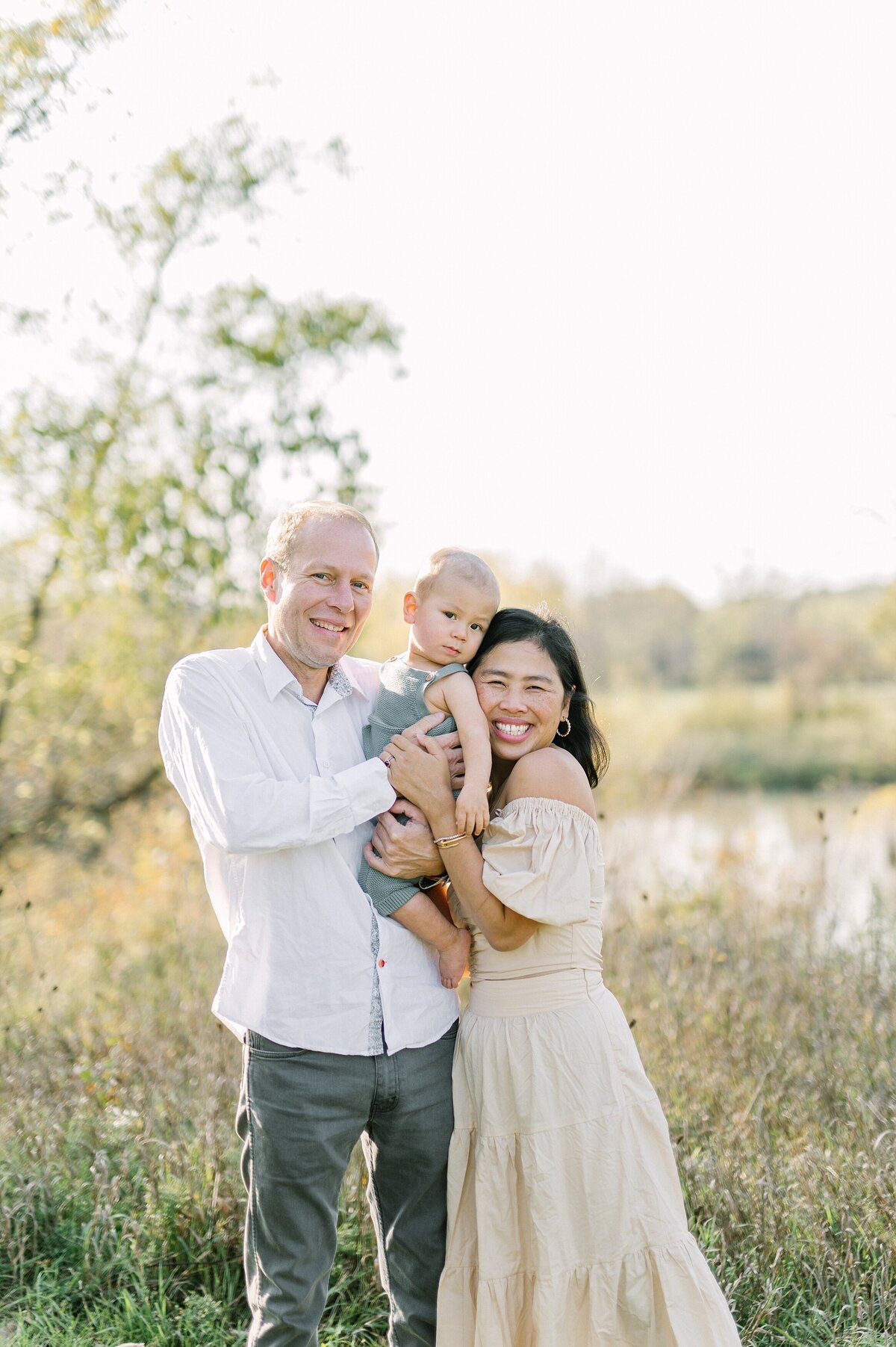 Family of three smiling at the camera for a Milwaukee family photo session
