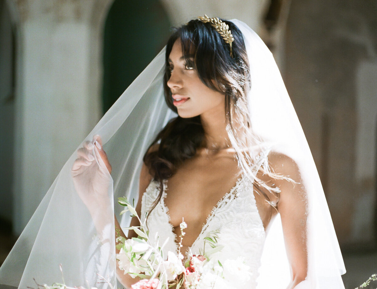 Indian bride in white veil, sunlight in abandoned cathedral ruins, wedding venue in Croatia, Mediterranean
