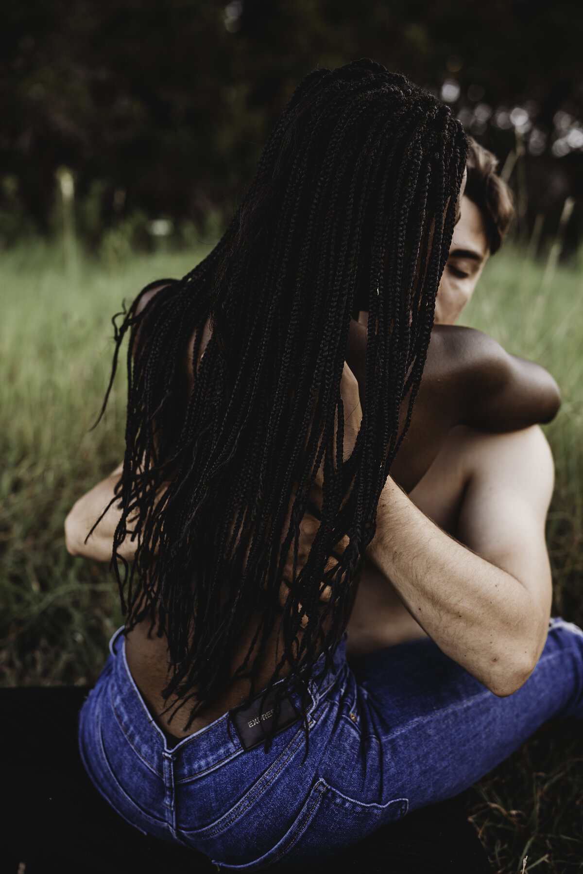 black woman and white man topless holding each other