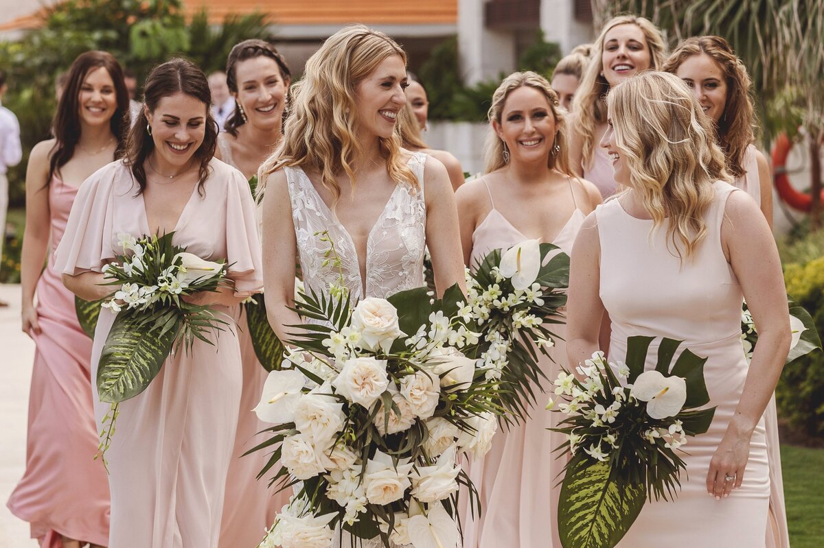 Bridesmaids laughing and walking at wedding in Riviera Maya