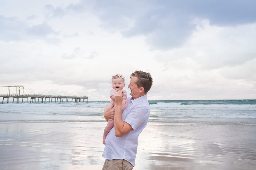 dad and 1 year old daughter on beach