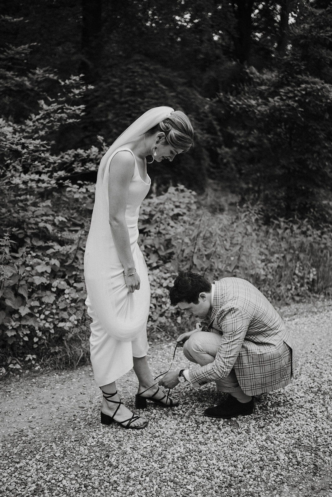 Bruidegom strikt de schoenen van de bruid