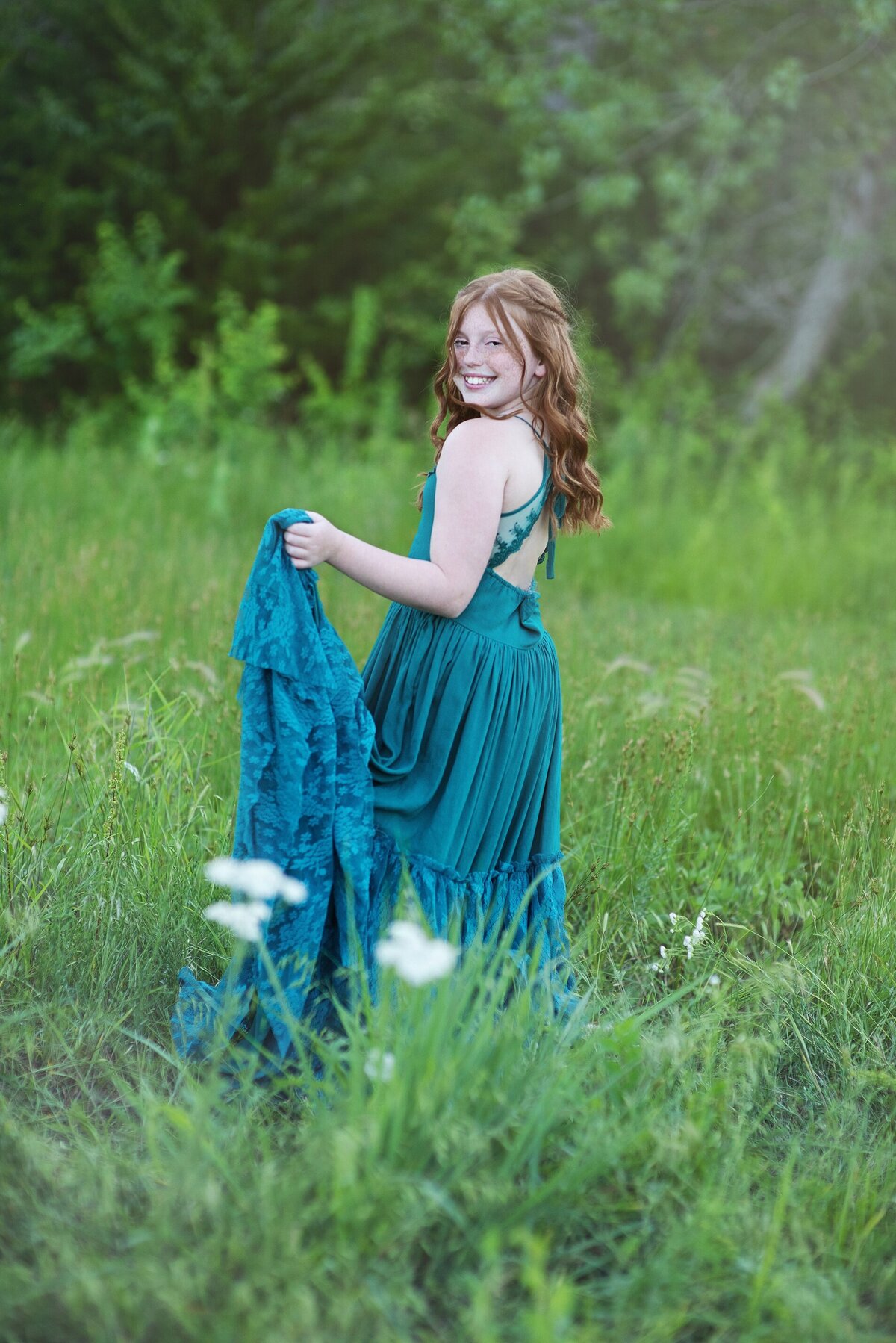 Teen twirling in boho dress in field