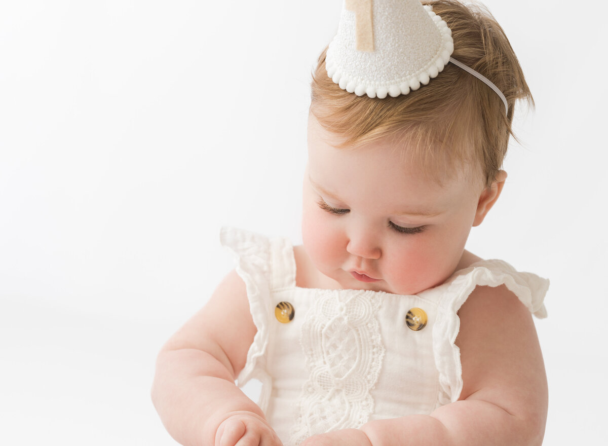 Baby wearing a party hat at a first birthday photoshoot by Hobart Photographer Lauren Vanier