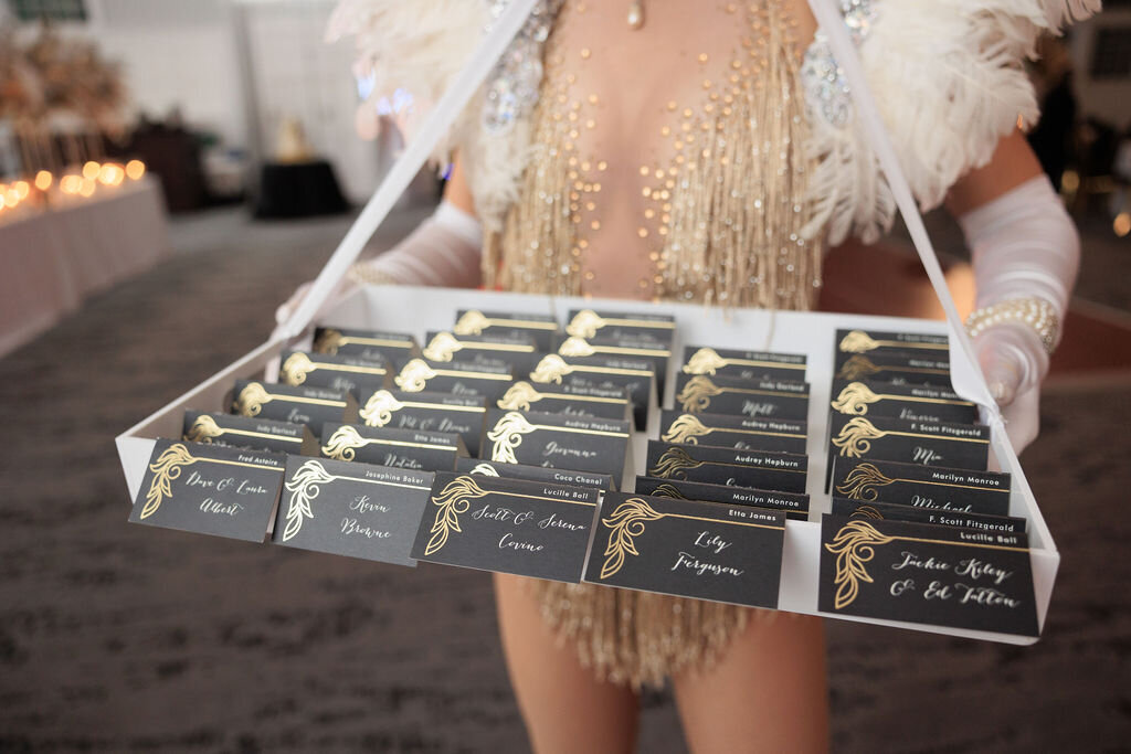 Great Gatsby escort cards being displayed by showgirls